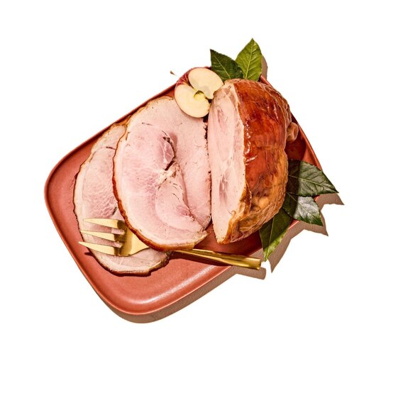 Sliced porchetta roast on a platter with apple garnish, festive holiday dinner entrée.